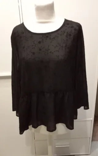 Blusa negra con estampado floral y volante
