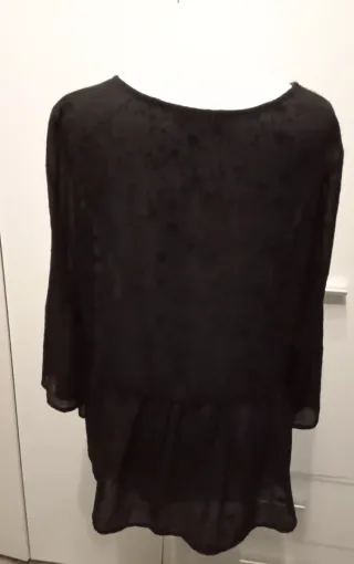 Blusa negra con estampado floral y volante