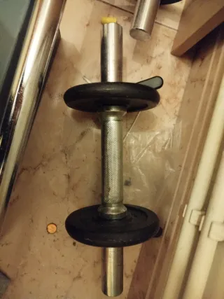 Barra olímpica con discos y pesas