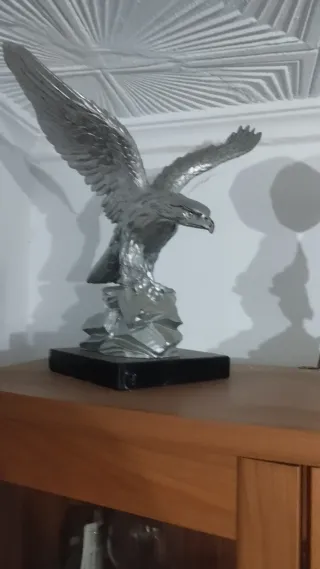 Lote 2 figuras plateadas: águila y niño