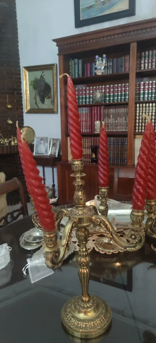 Candelabros antiguos de bronce con velas rojas