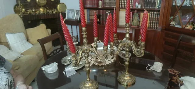 Candelabros antiguos de bronce con velas rojas