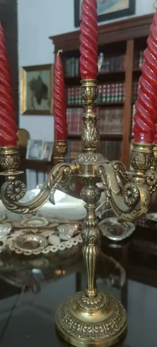 Candelabros antiguos de bronce con velas rojas