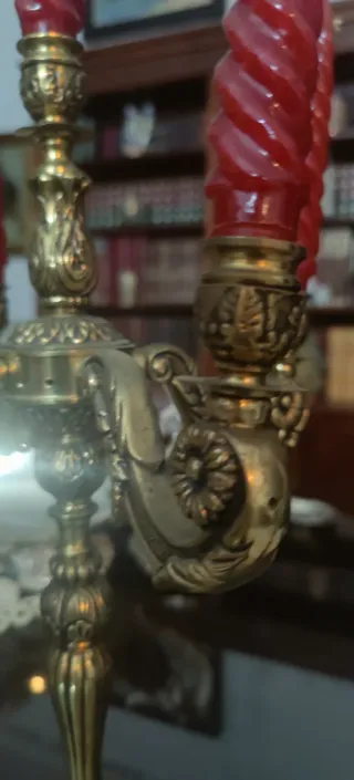 Candelabros antiguos de bronce con velas rojas