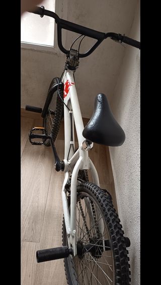 Bicicleta BMX blanca con detalles rojos