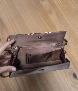 Bolso de mano marrón con detalle joya