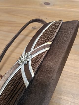 Bolso de mano marrón con detalle joya
