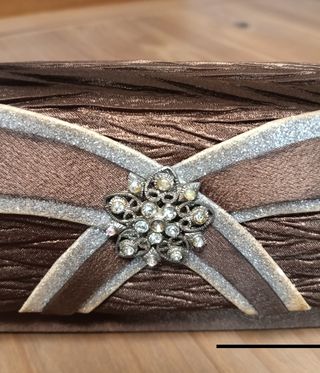 Bolso de mano marrón con detalle joya