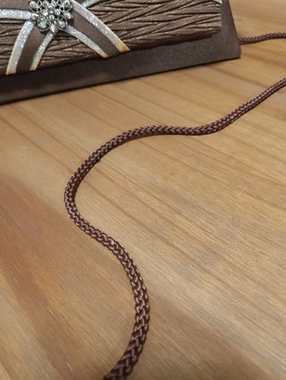 Bolso de mano marrón con detalle joya