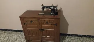 Máquina de coser Singer en uso. Con mueble