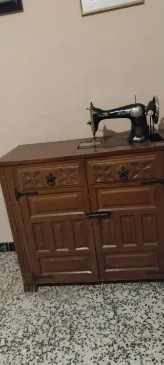 Máquina de coser Singer en uso. Con mueble
