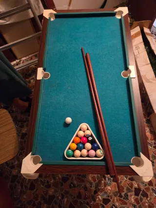Mesa de billar con tacos y bolas