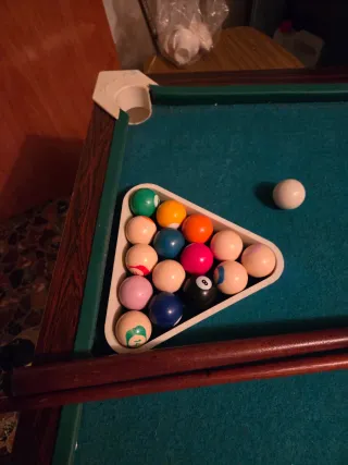 Mesa de billar con tacos y bolas