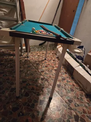 Mesa de billar con tacos y bolas