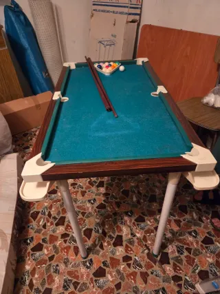 Mesa de billar con tacos y bolas