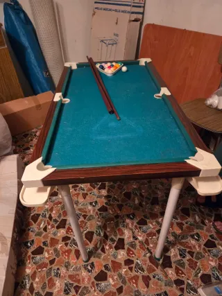 Mesa de billar con tacos y bolas