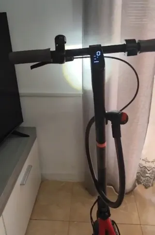 Patinete eléctrico rojo y casco homologado