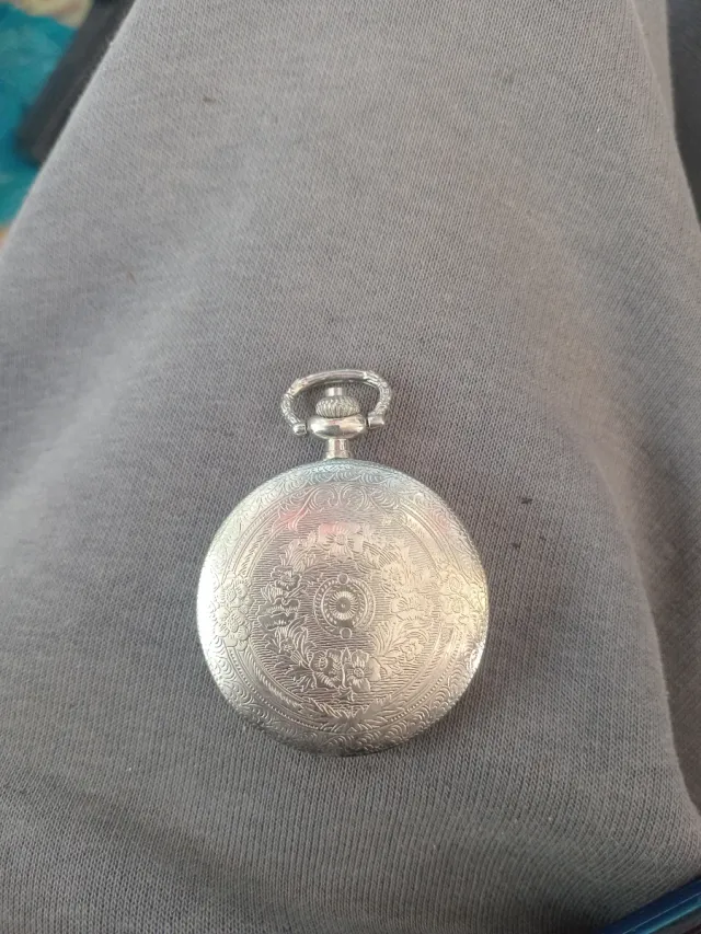 Reloj de bolsillo plateado con grulla