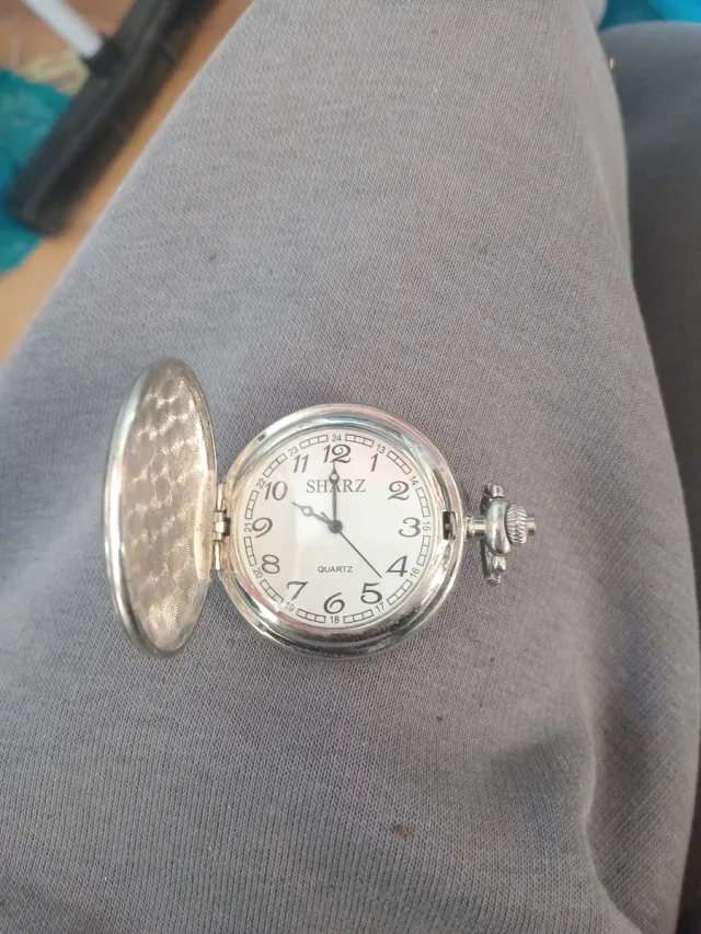 Reloj de bolsillo plateado con grulla