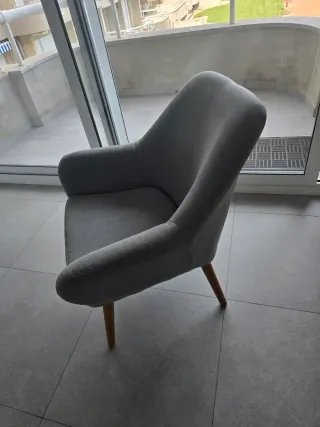 Sillón de tela gris con patas de madera