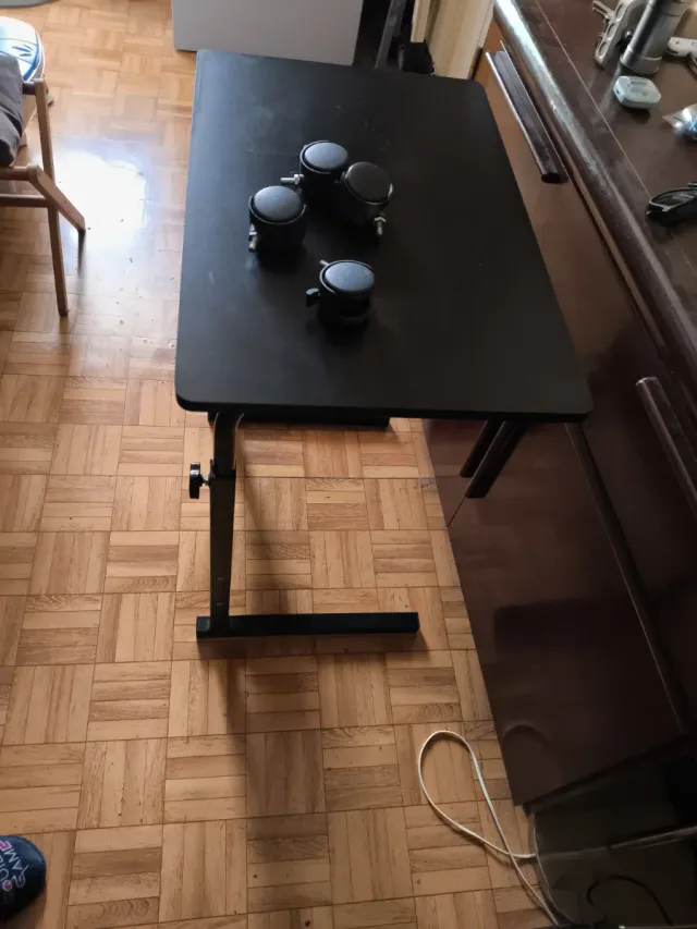 Mesa elevable negra con ruedas (una para arreglar)