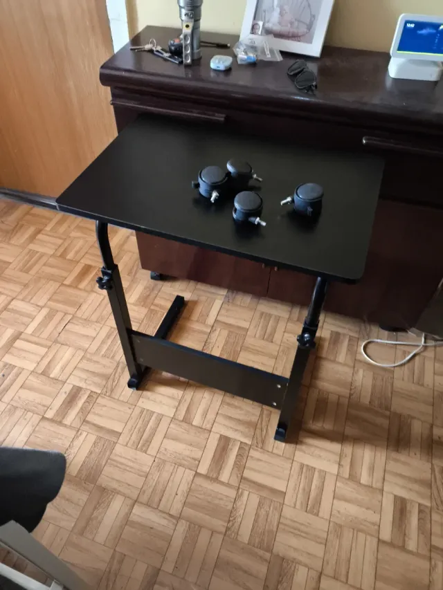Mesa elevable negra con ruedas (una para arreglar)