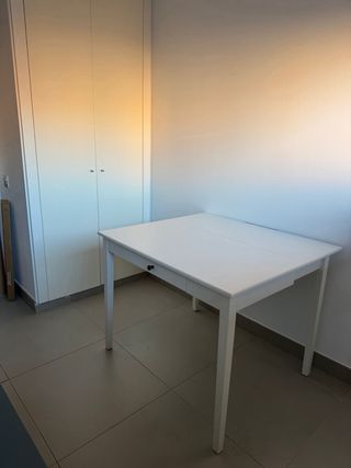 Mesa plegable de madera blanca con cajón.
