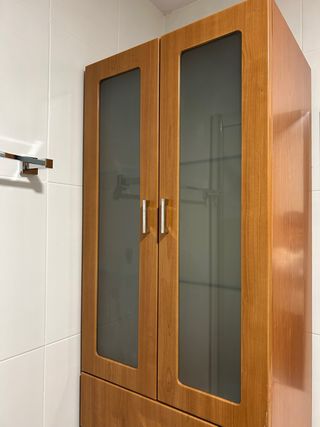 Mueble de madera alto con puertas de cristal