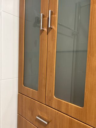 Mueble de madera alto con puertas de cristal