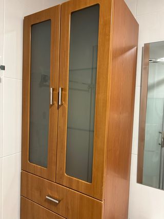 Mueble de madera alto con puertas de cristal