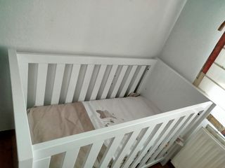 Cuna blanca con colchón y ropa de cama