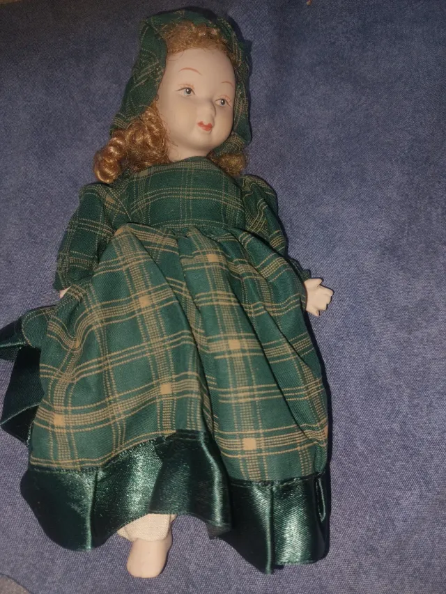 Muñeca de porcelana con vestido de cuadros