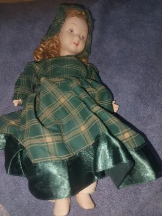 Muñeca de porcelana con vestido de cuadros