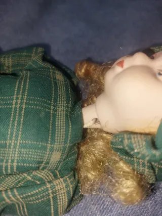 Muñeca de porcelana con vestido de cuadros