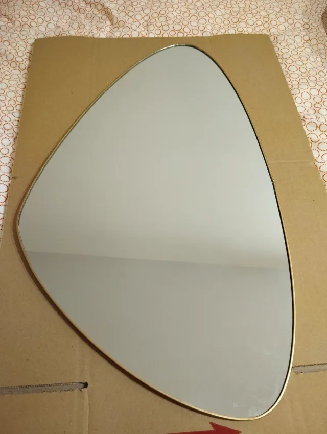 Espejo ovalado con marco dorado