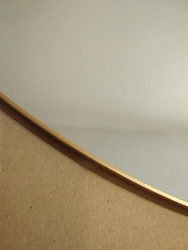 Espejo ovalado con marco dorado