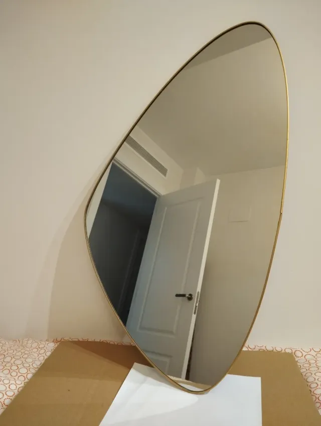 Espejo ovalado con marco dorado