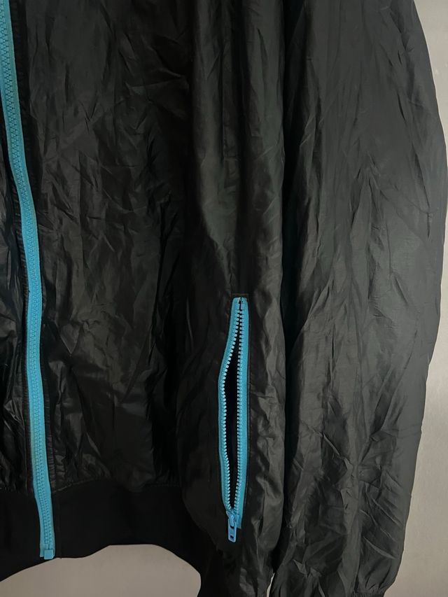 Chaqueta Nike impermeable negra y turquesa