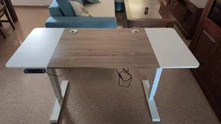 Mesa de escritorio elevable blanca y madera.