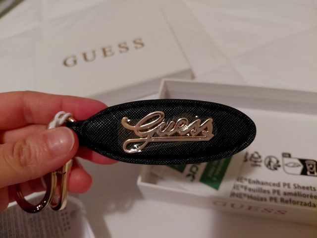 Portachiavi Guess nero con logo dorato.