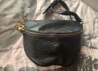 Riñonera negra con cadena dorada