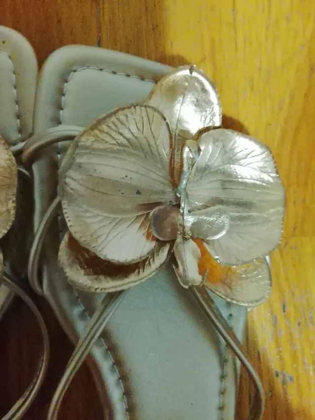 Sandalias doradas con detalle de flor