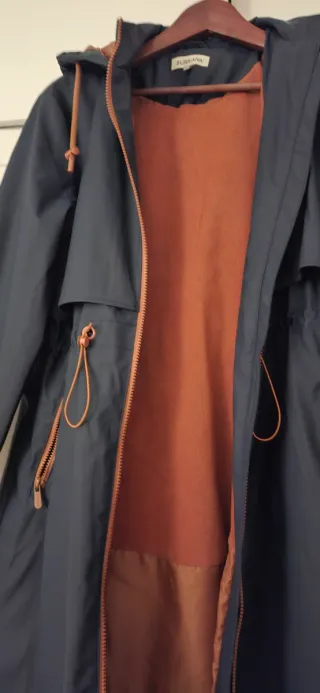 Gabardina azul marino con cremallera y forro.