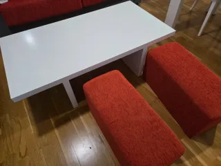 Mesa de salón blanca con 2 pufs rojos
