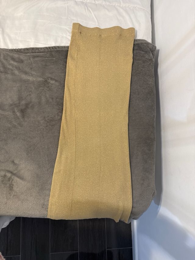 Falda dorada brillante con abertura lateral.