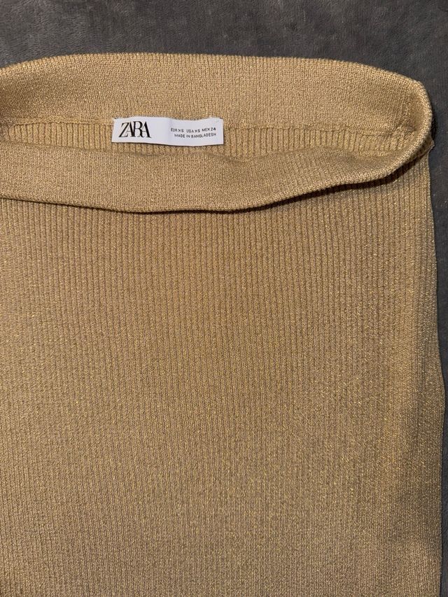 Falda dorada brillante con abertura lateral.