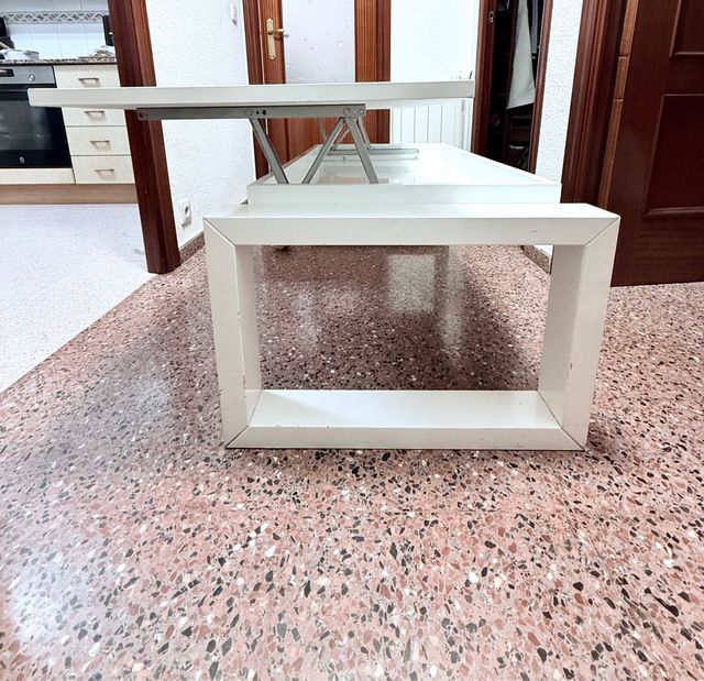 Mesa elevable blanca con almacenaje.