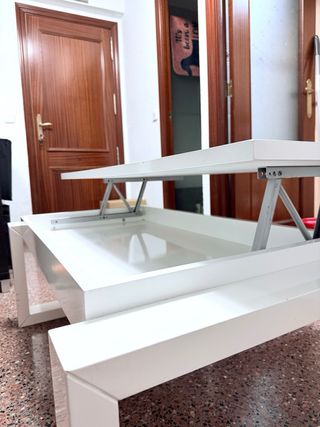Mesa elevable blanca con almacenaje.
