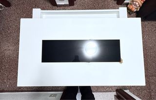 Mesa elevable blanca con almacenaje.