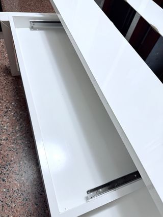 Mesa elevable blanca con almacenaje.